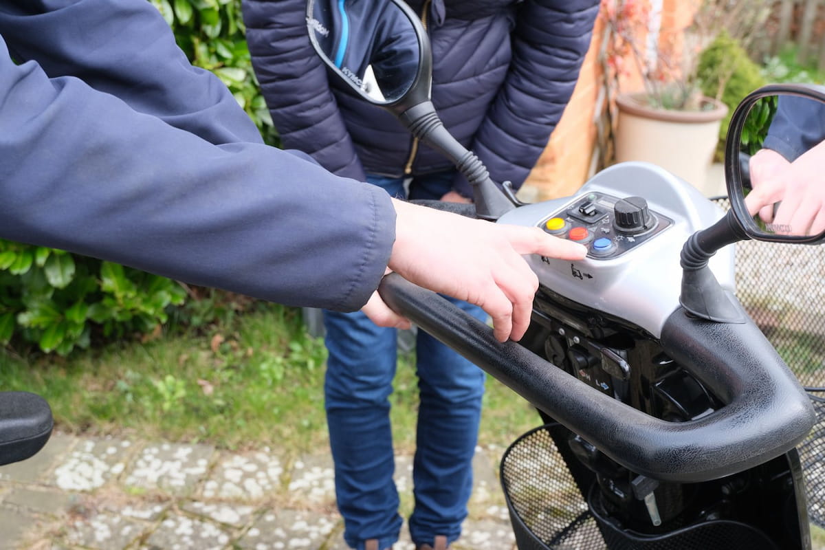 Engineer delivering and demonstrating an Excel scooter at a customer’s home